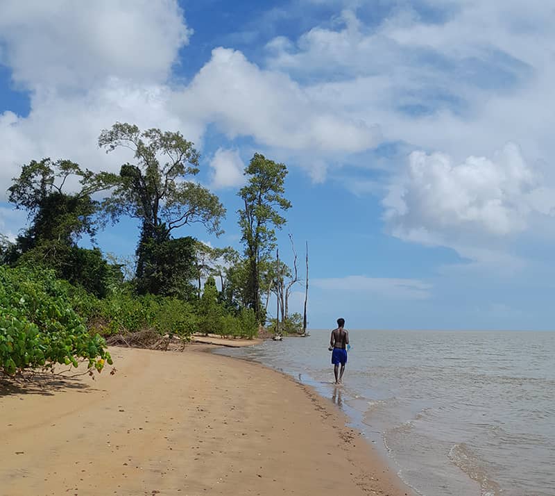 Personne de dos marchant sur la plage de Pointe Liberté à marais haute.