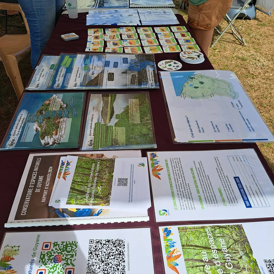 Stand d'animation et d'information du Cen Guyane avec de nombreux supports d'information, dans le cadre d'un évènement public.